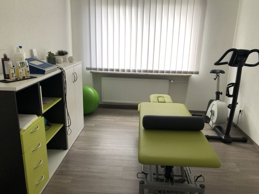 Behandlungsraum mit Therapieliege, Gymnastikball und Ergometer