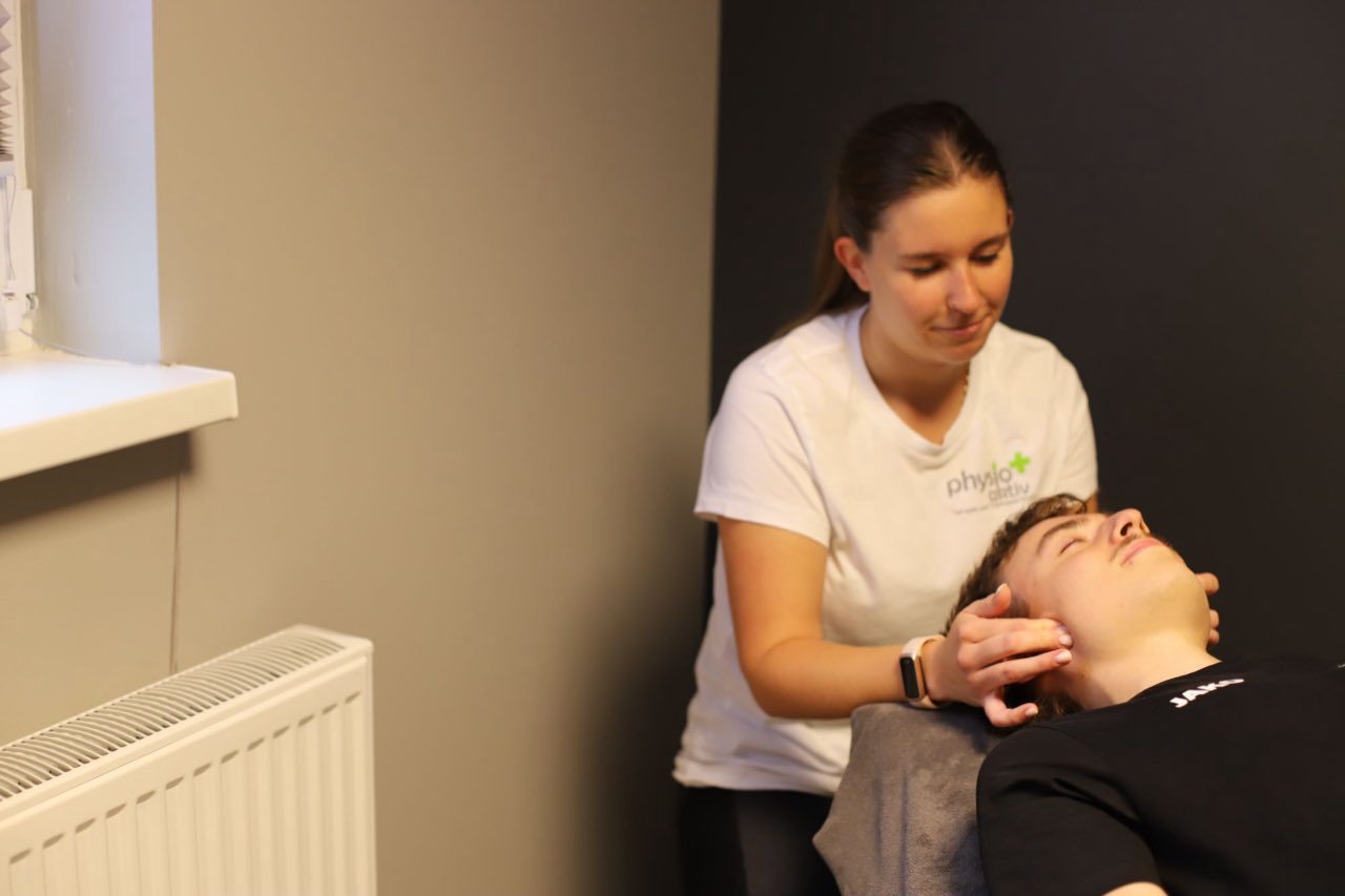 Physiotherapeutin im Gespräch mit einem Patienten während der Befundung